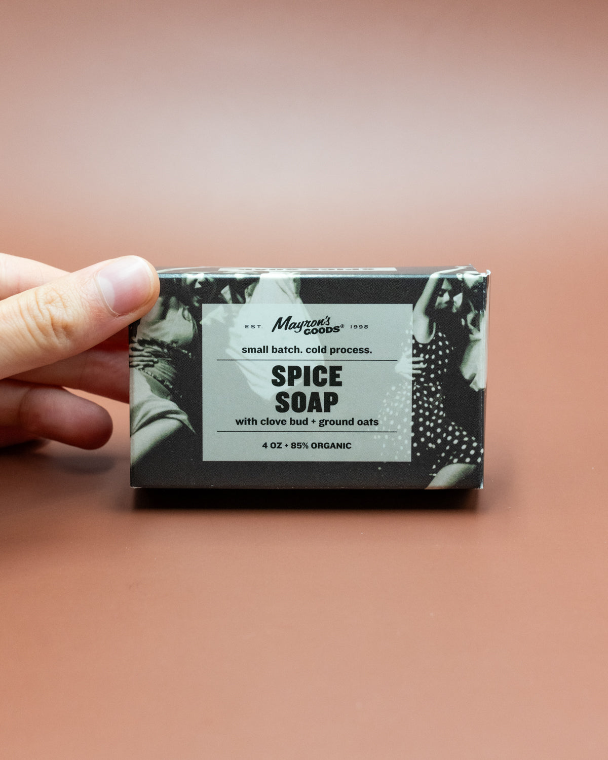Hand holding a boxed bar of Mayron's Goods Spice Soap with clove bud and ground oats