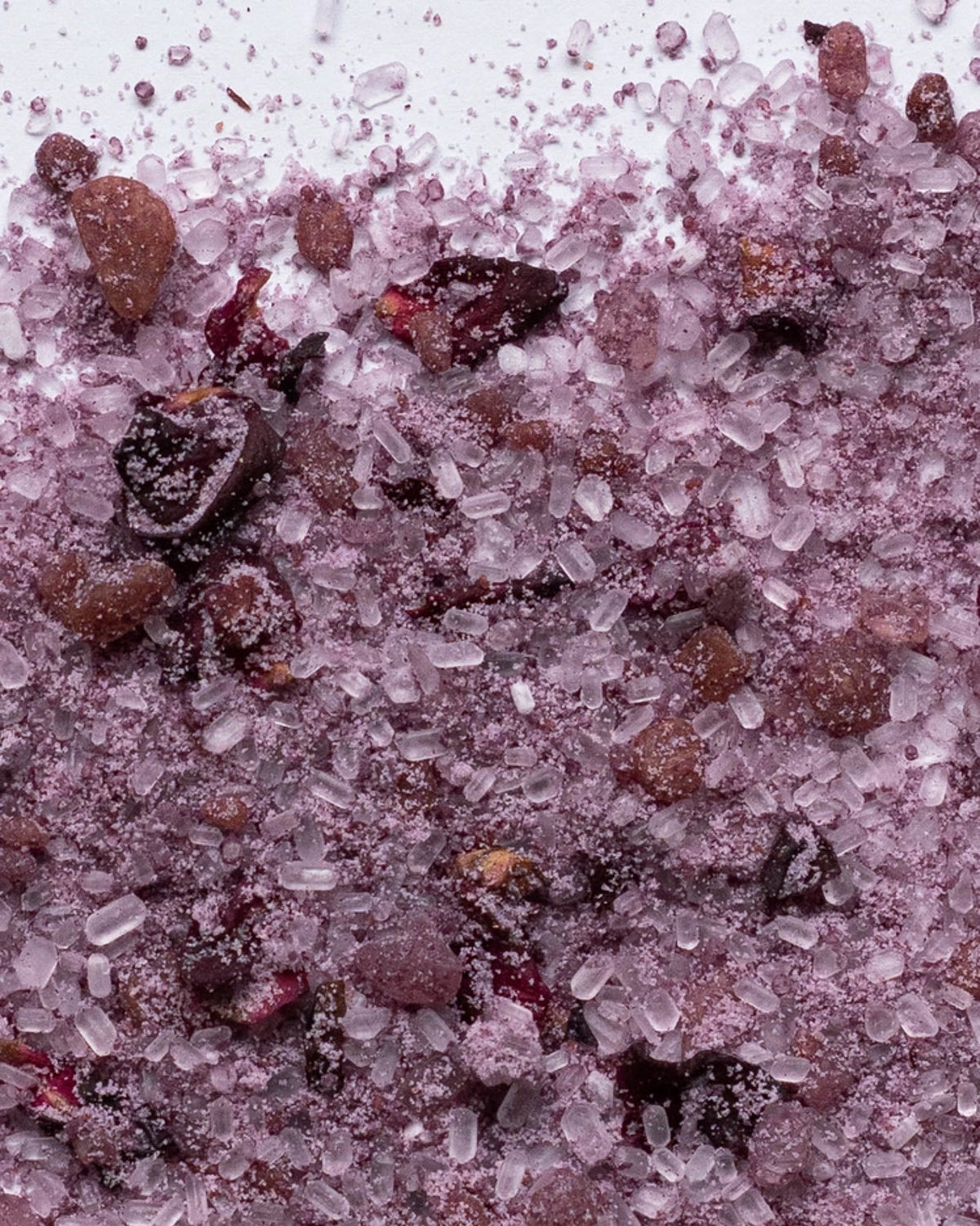 Close-up of pink Himalayan bath salts mixed with dried rose petals
