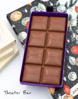 Close up of opened box of Miss Maude's Theater Bar featuring 8 milk chocolate squares in different flavors on a holiday illustration background
