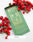 Miss Maude's Holiday milk chocolate bar in a green wrapper beside red berries