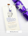 Miss Maude's Whiskey Business milk chocolate bar next to a purple party cracker