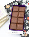 Open Miss Maude's Theater Bar showing milk chocolate squares stamped with flavors like popcorn and mint