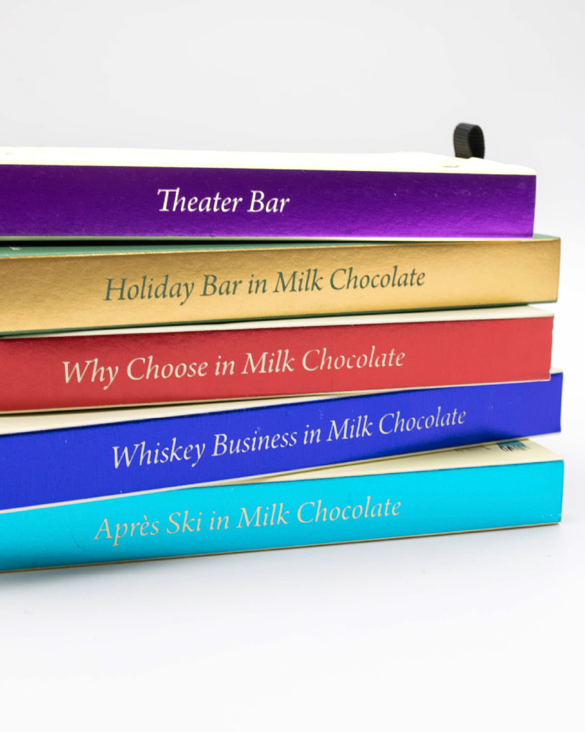 Stack of five Miss Maude's milk chocolate bars in colorful boxes