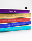 Stack of five Miss Maude's milk chocolate bars in colorful boxes