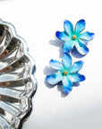 Nach Bijoux Frost Flower earrings in hand-painted blue porcelain beside a silver dish