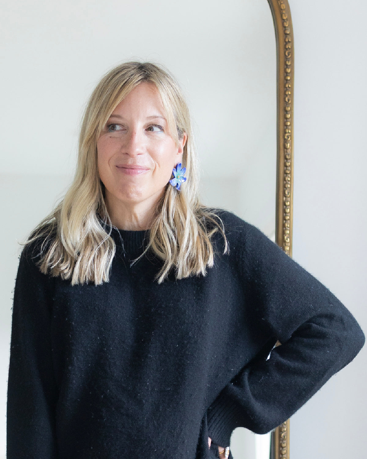 Woman posing in a black sweater while wearing Nach Bijoux's Frost Flower earrings