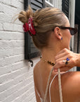 Woman seen from behind in a red claw clip, wearing the Once Upon a Time ring on her hand