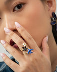 Woman with a hand to her face wearing the Once Upon a Time porcelain bird and flower ring