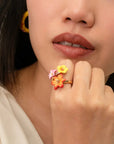 Nach Bijoux hand-painted porcelain floral and gold ring worn on a person's finger