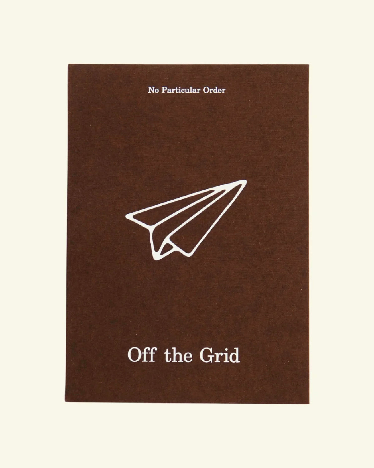 Off the Grid travel journal cover in brown with a white paper airplane drawing