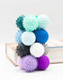 Stack of ONO Signet textured magnetic fidget balls in teal, lavender, graphite and sapphire
