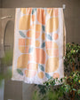 Turkish cotton towel with orange and green pattern hanging in a bathroom.