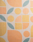 Fabric with geometric pattern of circles and leaves in orange, yellow, and blue. 