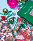 Tinseltown puzzle in progress with loose pieces, ornaments and its green box
