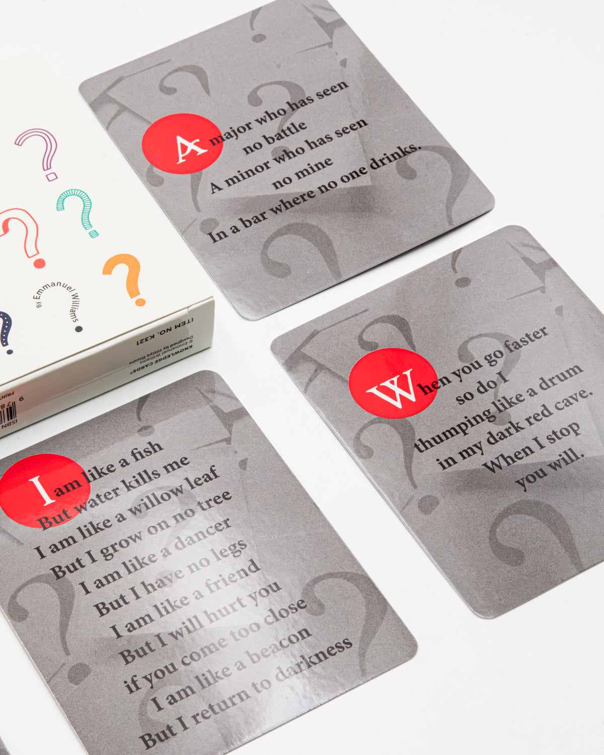 Riddles Vol. 1 cards with rhyming riddles in black type on gray, each marked with a red letter