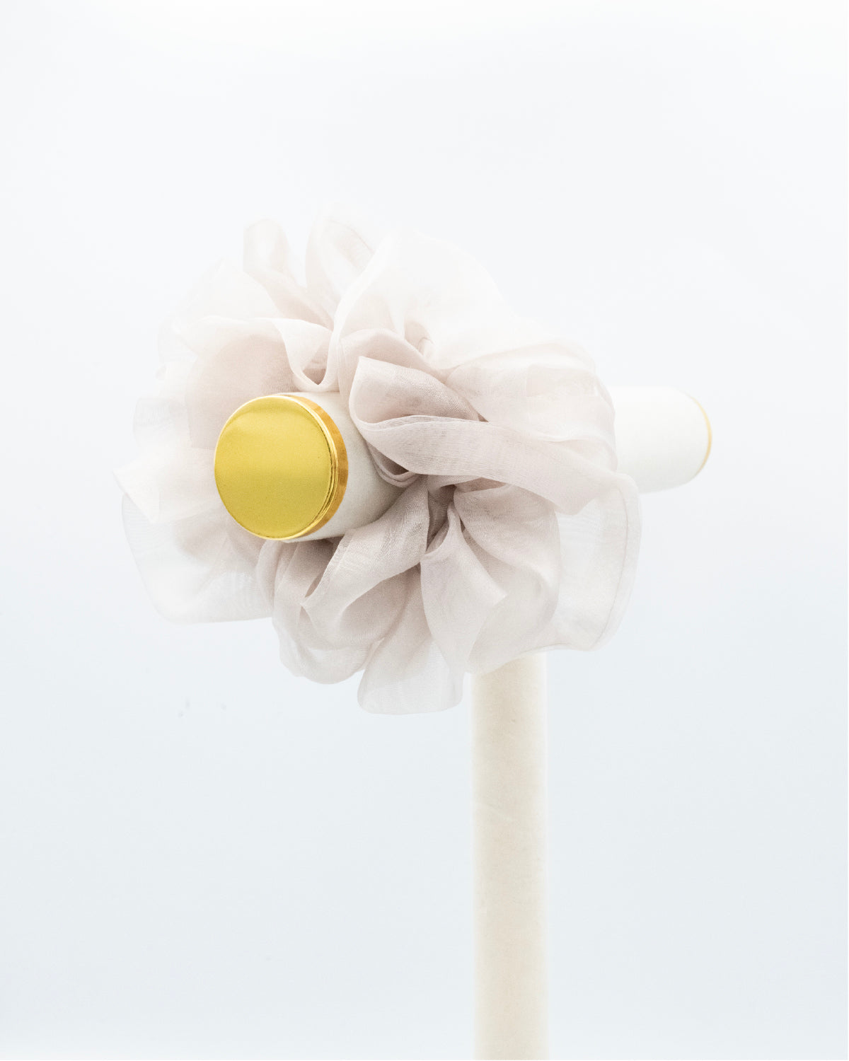 Oversized, cloud colored organza scrunchie on a peg.