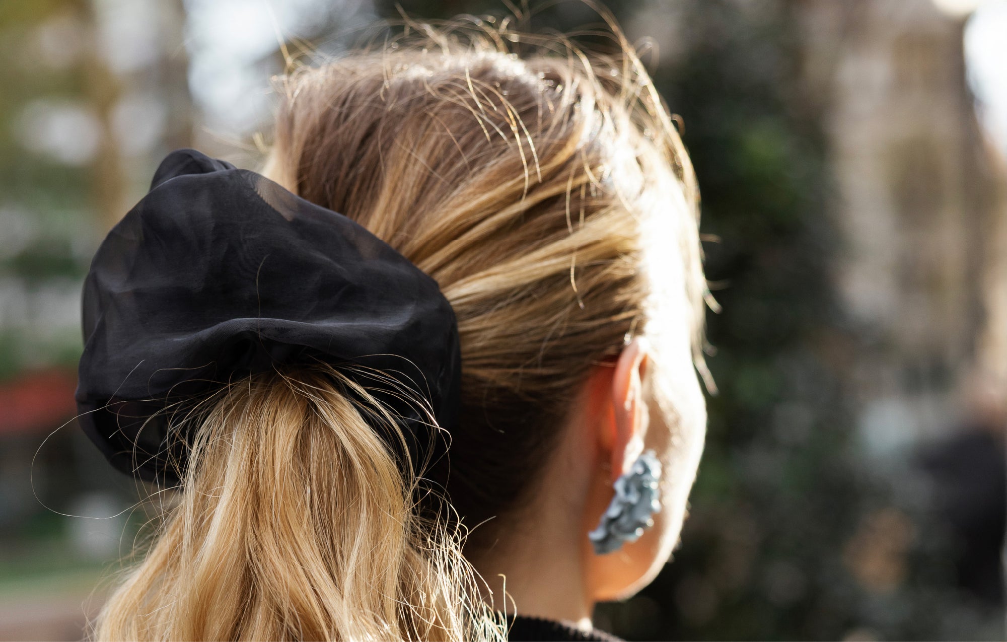 Close up of oversized, black organza scrunchie on a woman with a blonde ponytail