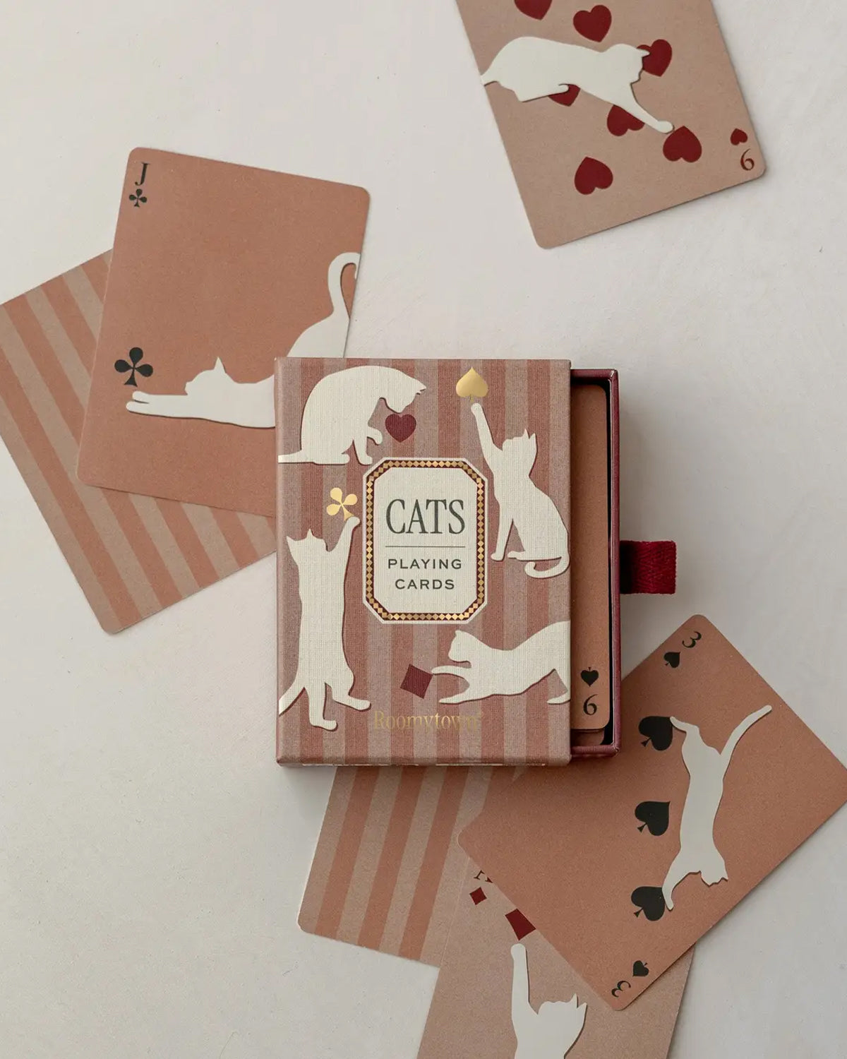 Roomytown Cats playing card deck in a dusty rose box with cards showing cream cat silhouettes