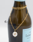 Pearl with set-in white topaz gemstone on a gold paperclip chain necklace