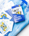 Ski House Games playing cards with skier face cards spread on a blue snow print