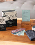 Self Care Adventure Cards box, guidebook and fanned cards on a wooden coffee table