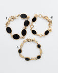 Vintage AMCO black onyx gold-filled bracelets displayed flat on a white background, featuring three sizes with polished onyx stones and detailed gold-fill links, each with an attached chain guard.