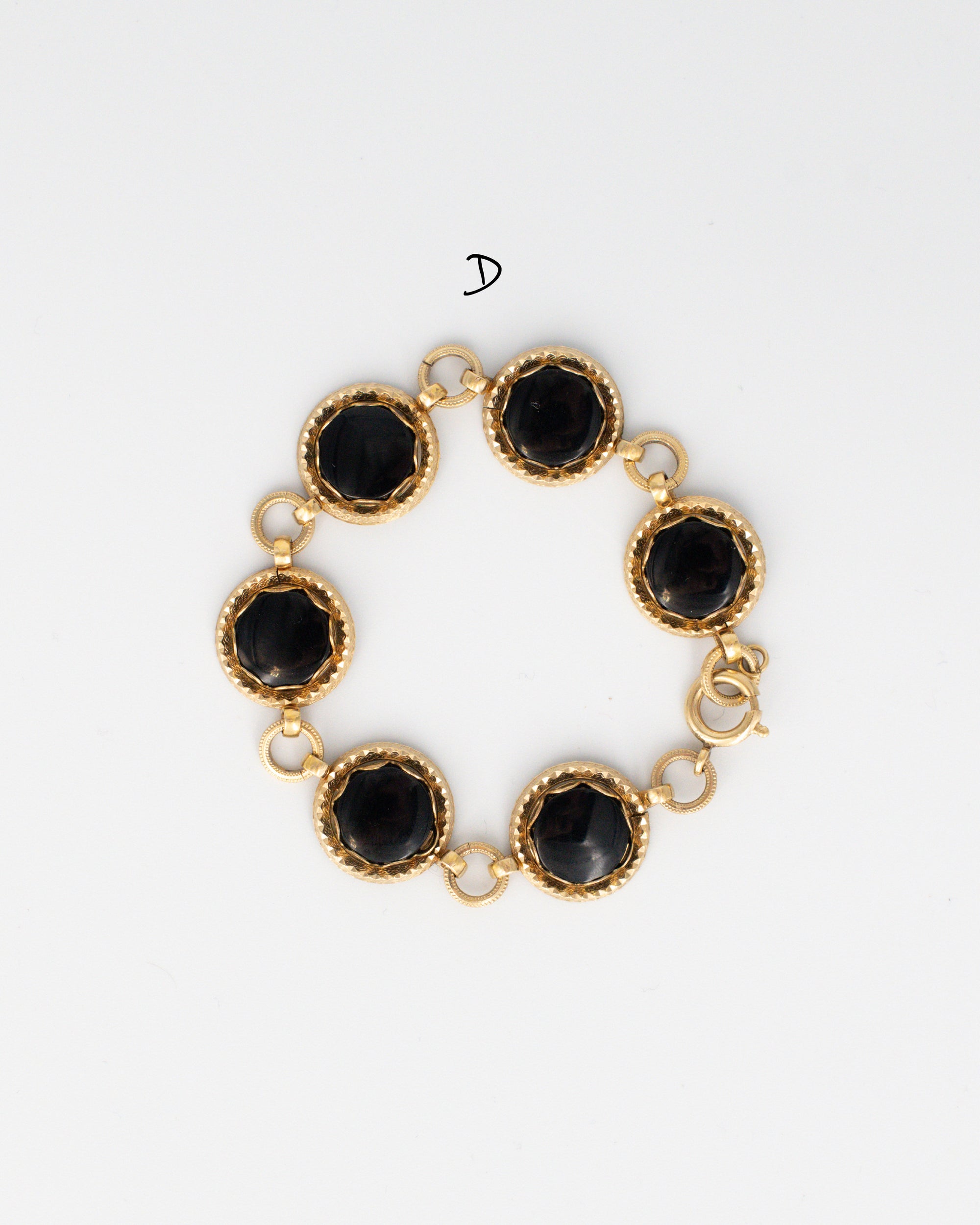 Vintage Jacoby-Bender black onyx bracelet with polished oval onyx stone and 12K gold-filled links displayed on a white background.