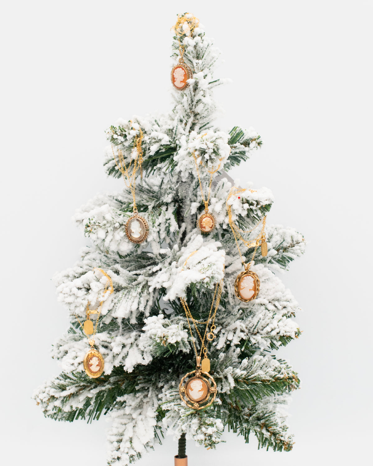 Vintage cameo necklaces on a faux, snow-covered, small Christmas tree