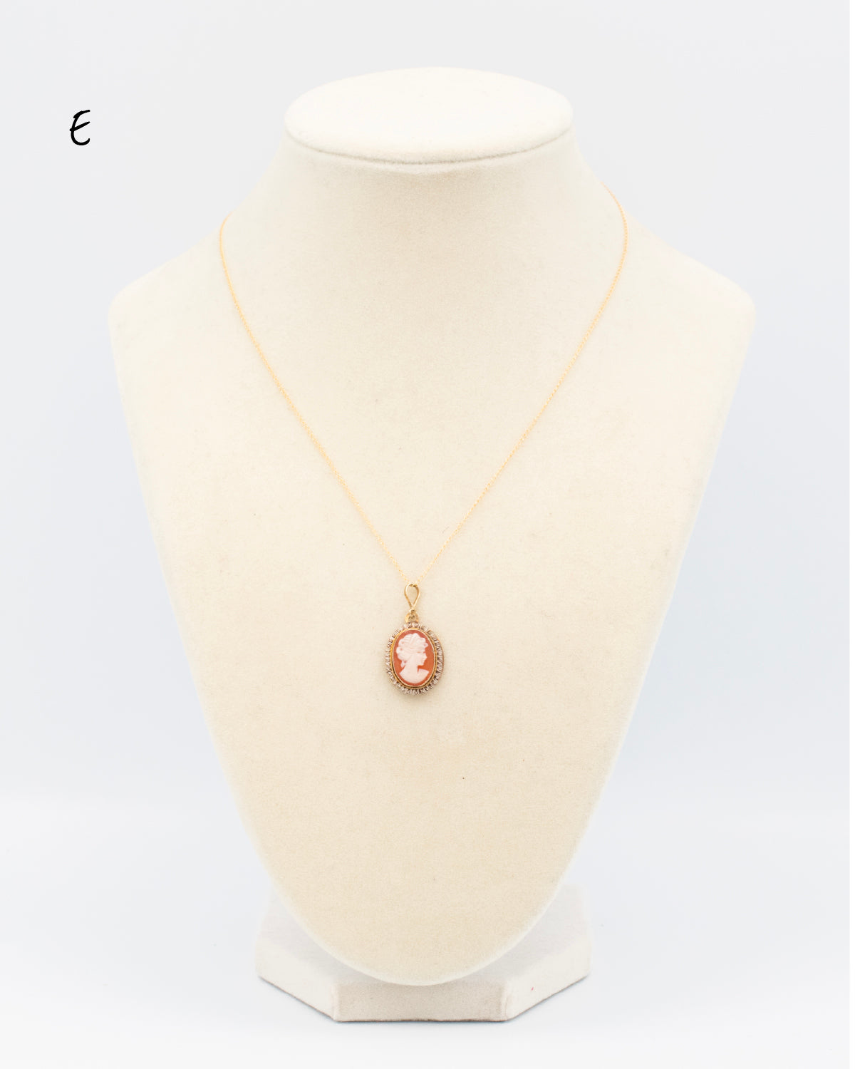 Hand-carved shell cameo in ruffle-edge gold-filled setting from the 1950s-60s, displayed on jewelry bust