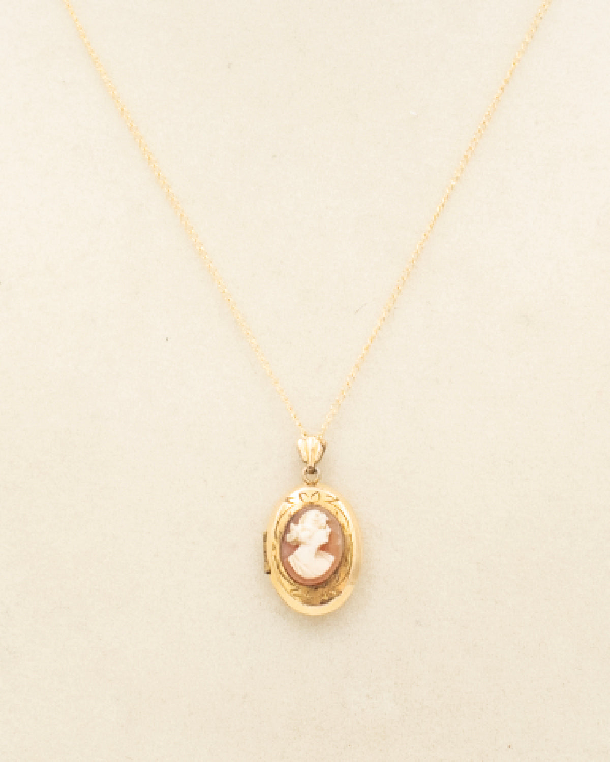 Vintage gold-filled cameo locket with shell cameo, etched scrollwork, textured back, opens to reveal red silk moire panel and tiny sepia portrait