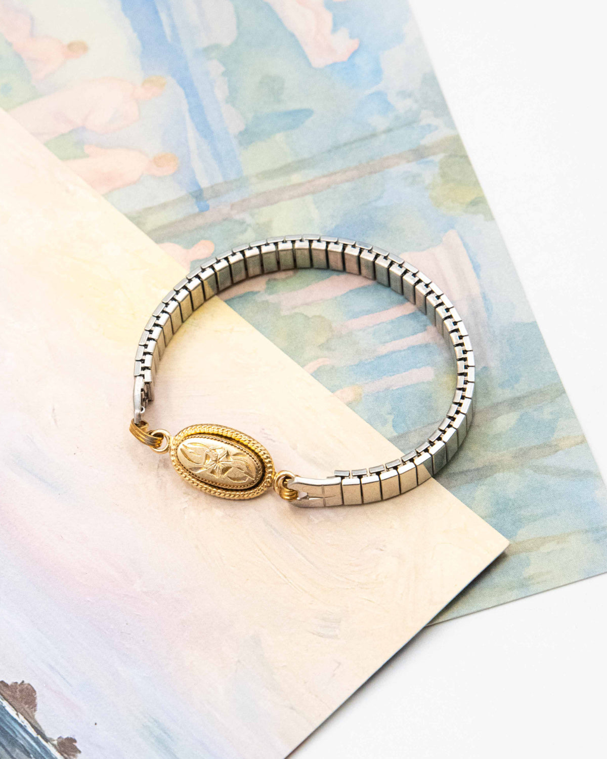 Candlelit Bloom bracelet with an etched gold-fill oval link on a vintage steel watch band