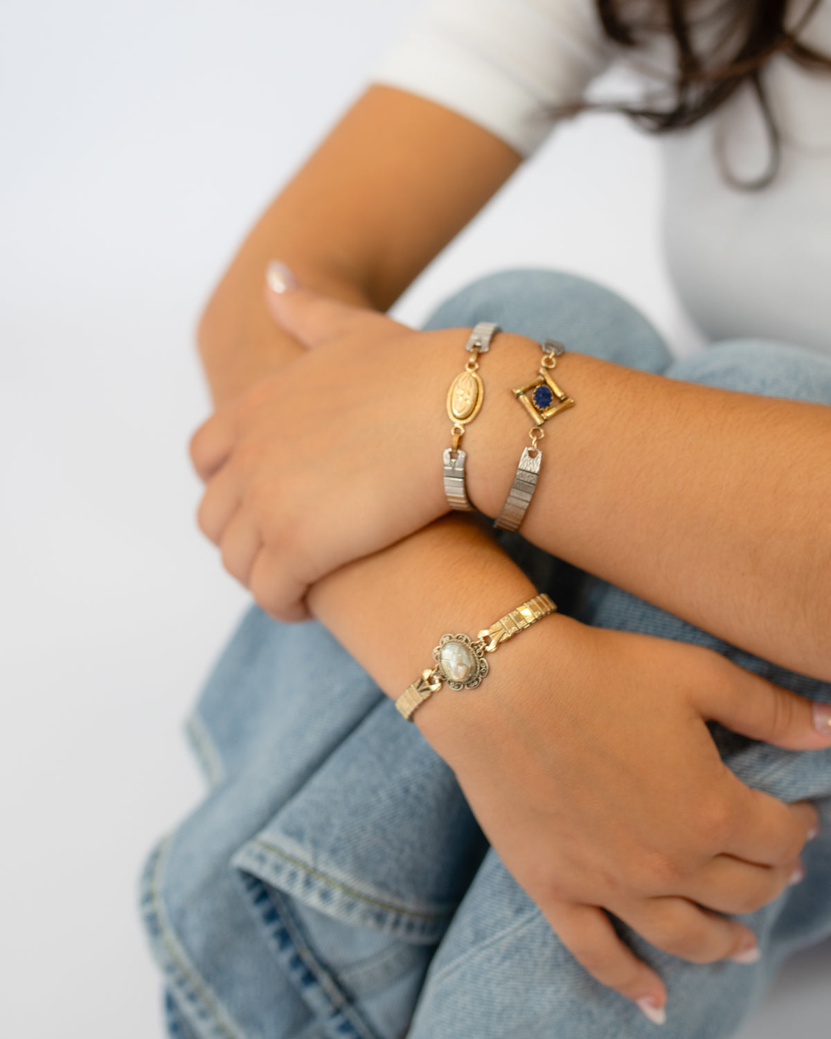 Woman wearing the Candlelit Bloom watch band bracelet stacked with two other bracelets