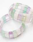 Close-up of two overlapping fluorite beaded bracelets highlighting the translucent green, purple, and clear banded stone beads.