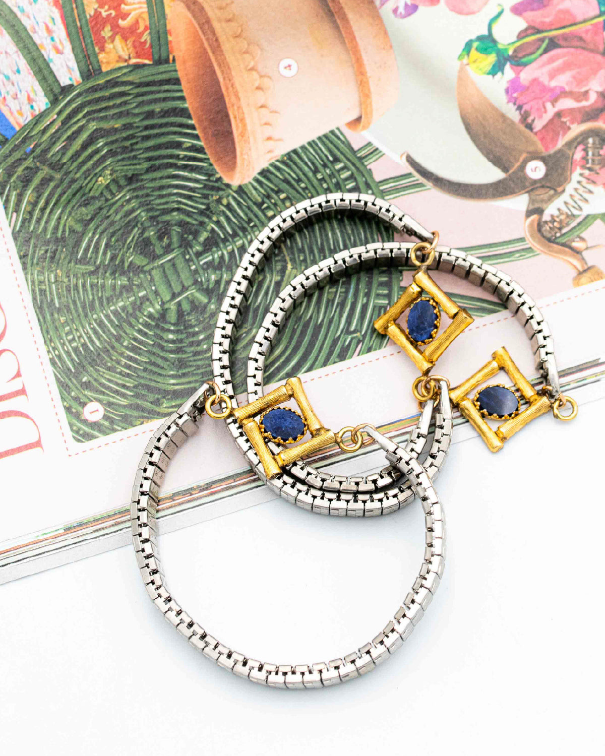 Vintage silver watch band bracelets with gold bamboo links and lapis stones on a woven mat
