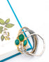 Three green scarab watch band bracelets on a white surface with a blue ribbon and leaf design.