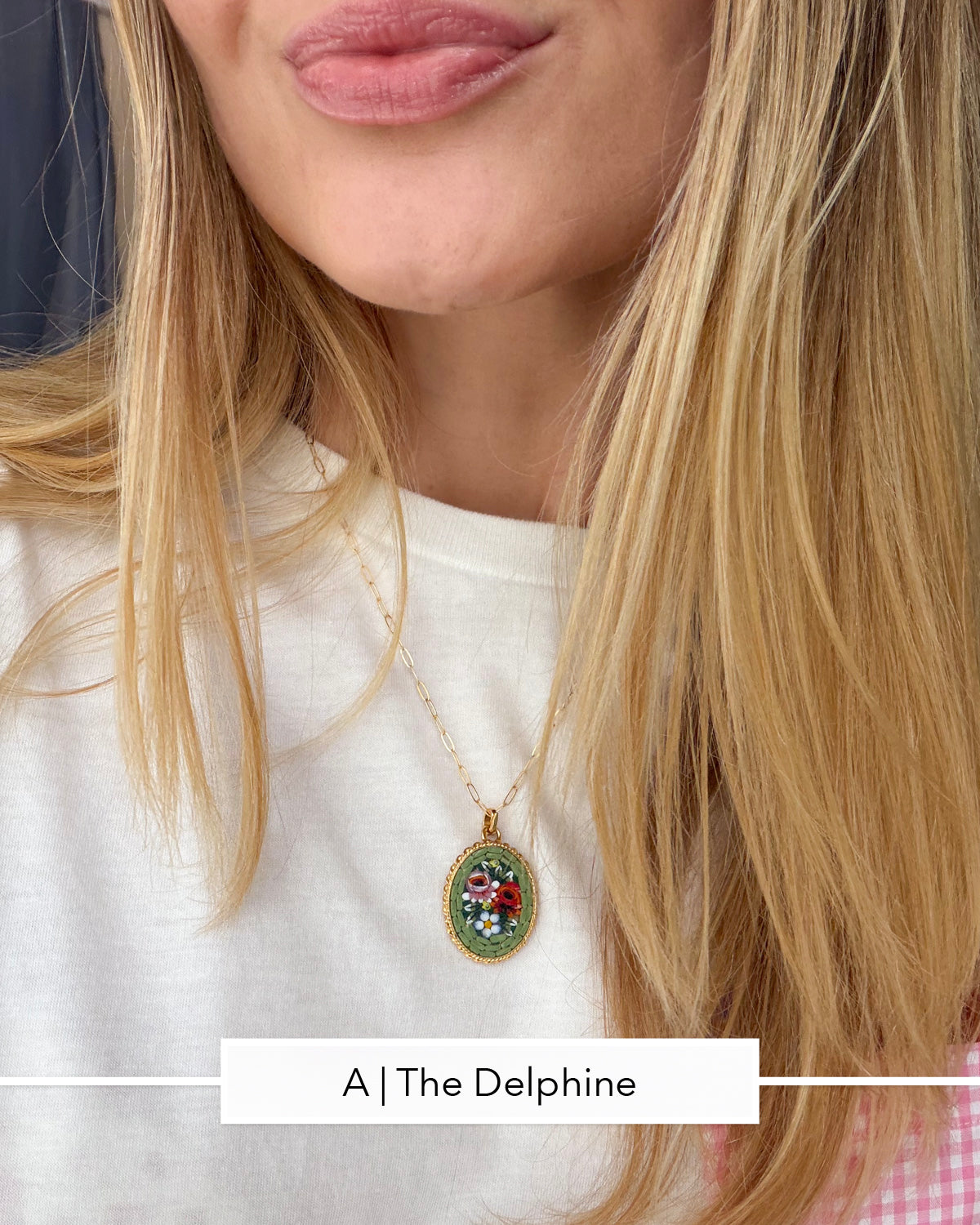 A close-up lifestyle shot of a woman wearing a gold chain necklace with an oval micro mosaic pendant featuring a colorful floral design.