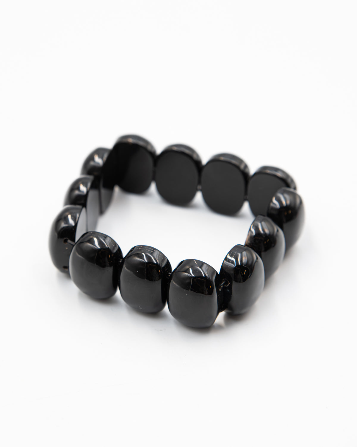 Single black onyx beaded stone bracelet with polished chunky beads photographed flat against a white background.