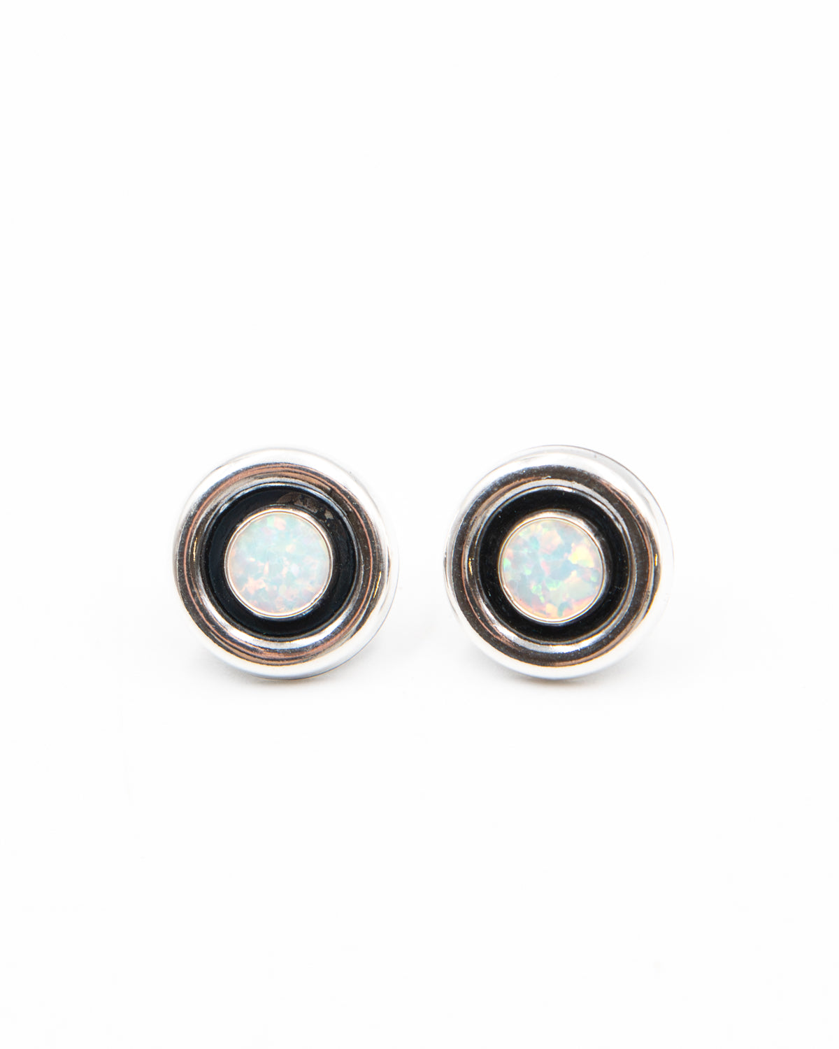 Pair of round vintage opal earring studs with black and silver rims on a white background