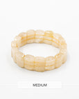 Single rutile quartz beaded stone bracelet with translucent honey-toned beads photographed flat against a white background.