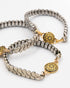 Closeup of three silver vintage watch band bracelets featuring a Damascene medallion with an intricate burst motif