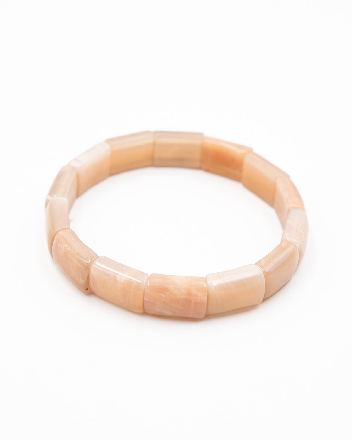Single sunstone beaded stone bracelet with tumbled peach-toned beads photographed flat against a white background.
