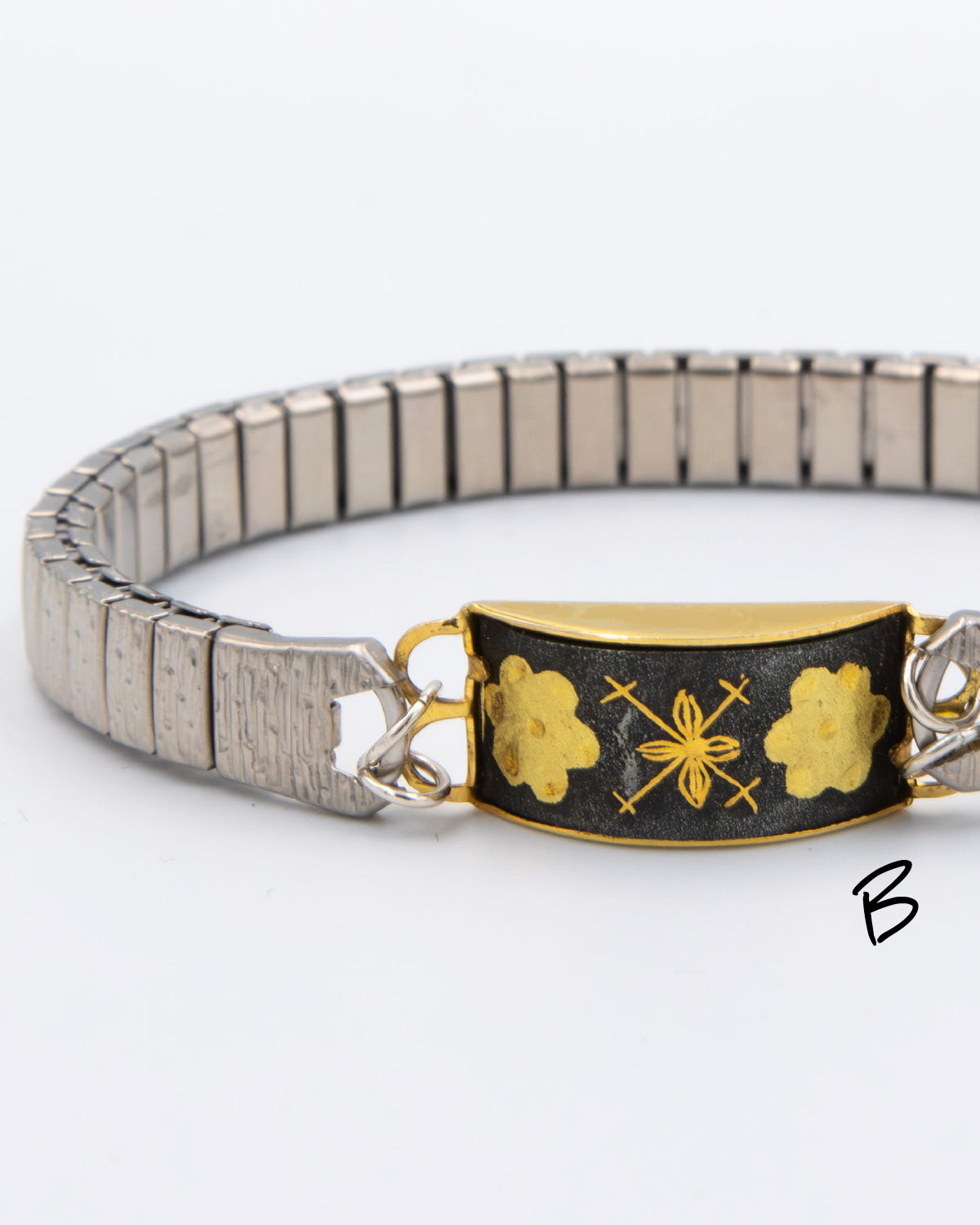 Bracelet with gold and black design on a white background