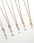 Five antique gold-filled chatelaine necklaces with dog clip clasp closures are arranged diagonally on a white background, labeled A through E.
