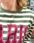 Person wearing a green and white striped shirt with a Victorian-era chatelaine slider necklace