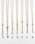 Six gold-filled and solid gold Victorian-era chatelaine lariat slider necklaces with small pendant charms are displayed vertically on a white background, labeled A through G below each.