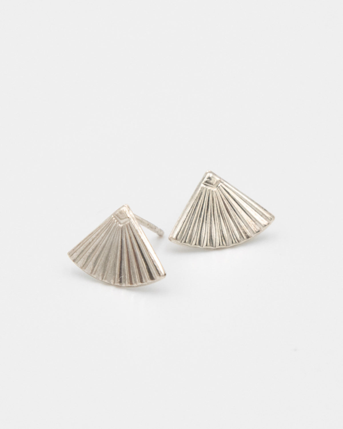 Pair of silver fan-shaped earrings on a light gray background