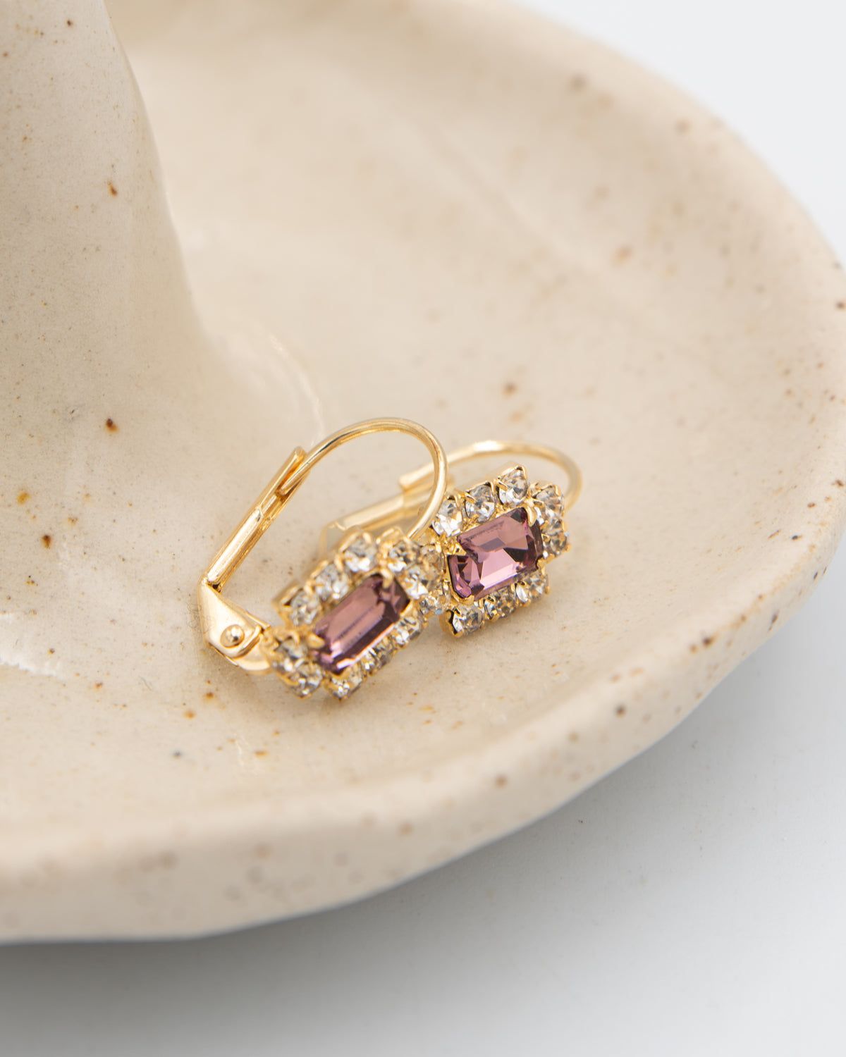 Stone Cooper Violet Hour vintage leverback earrings with purple glass stones in a ceramic dish