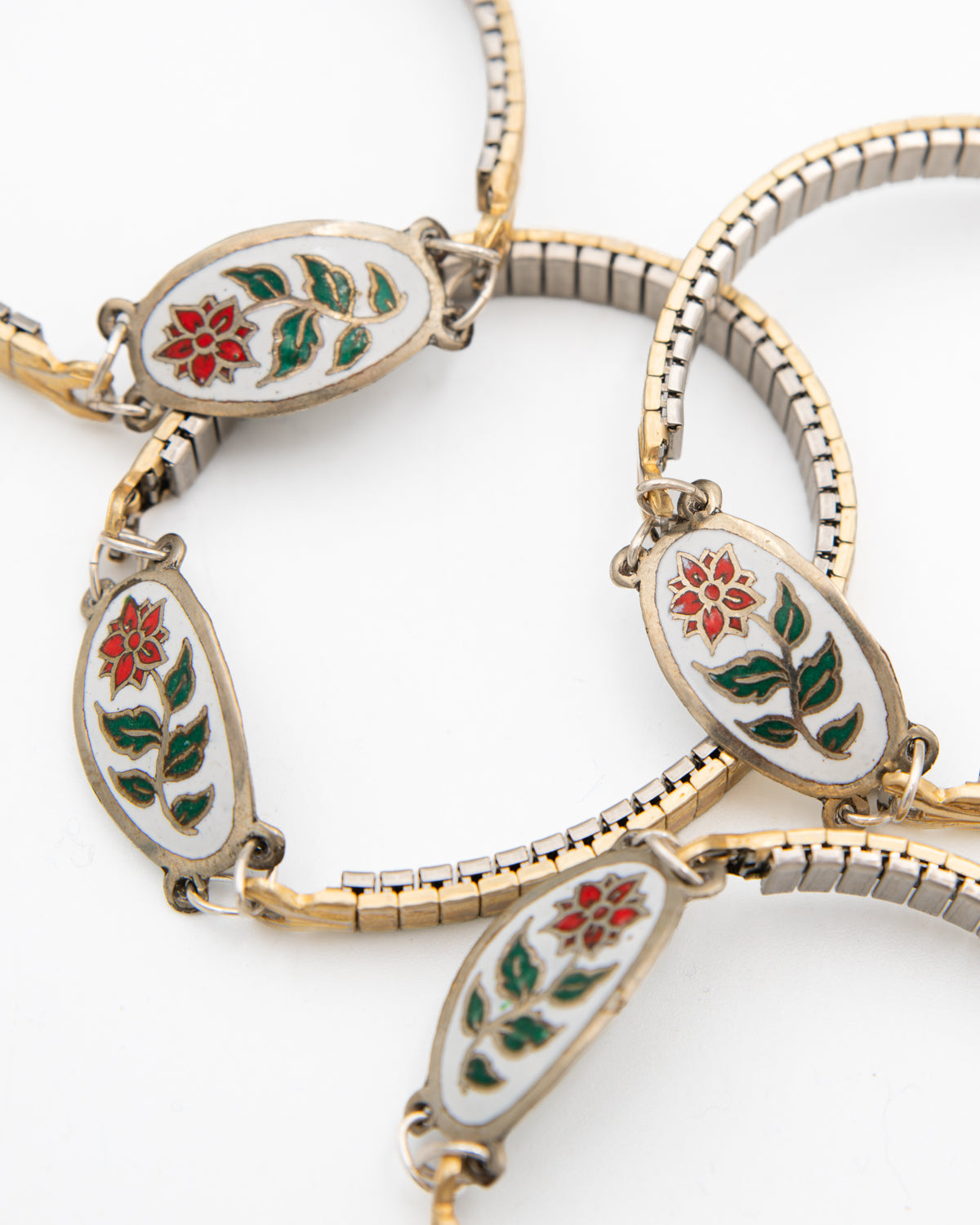 Several Winter Bloom bracelets with white enamel poinsettia links on vintage watch bands