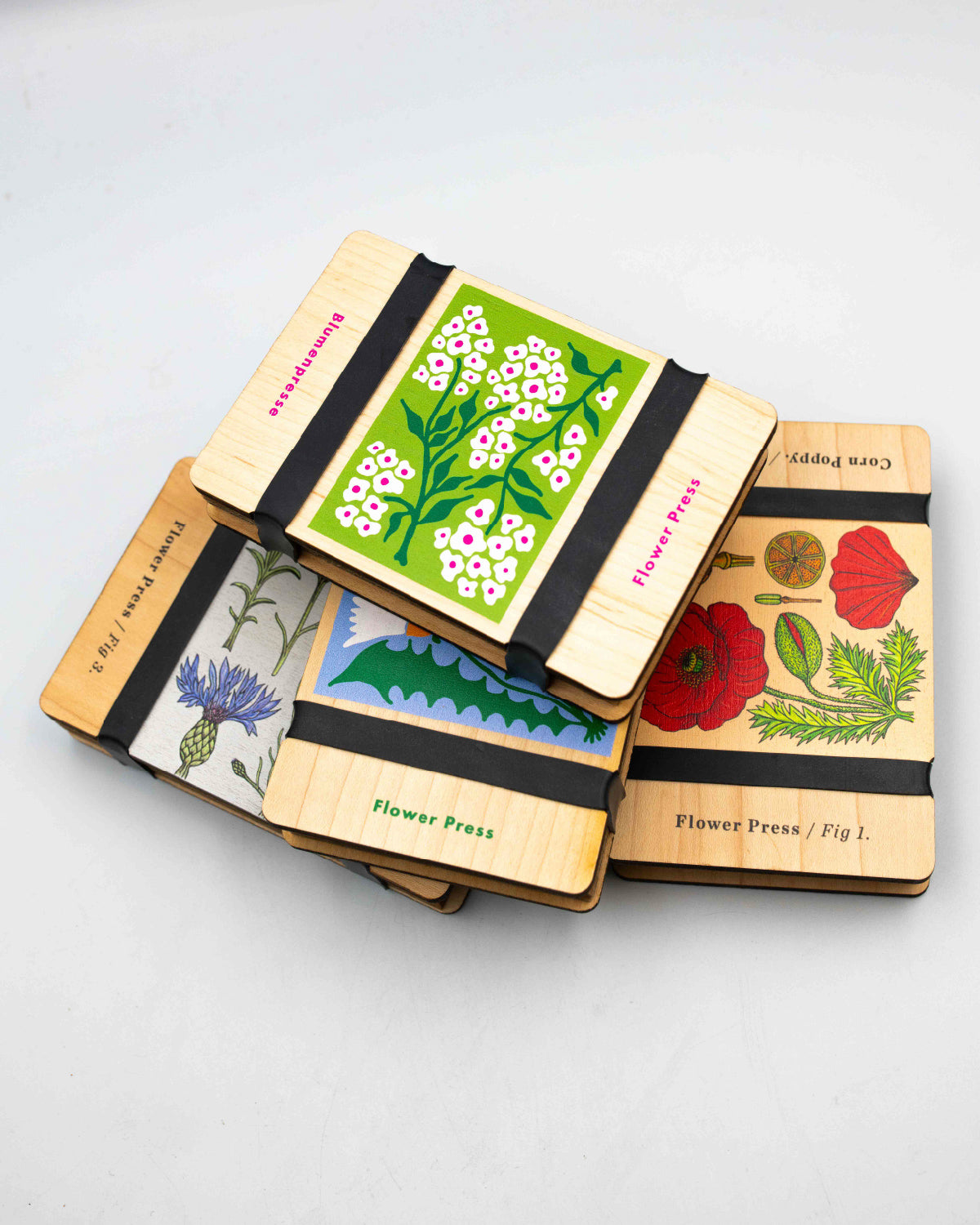 Stack of Studio Wald wooden flower presses in assorted botanical prints