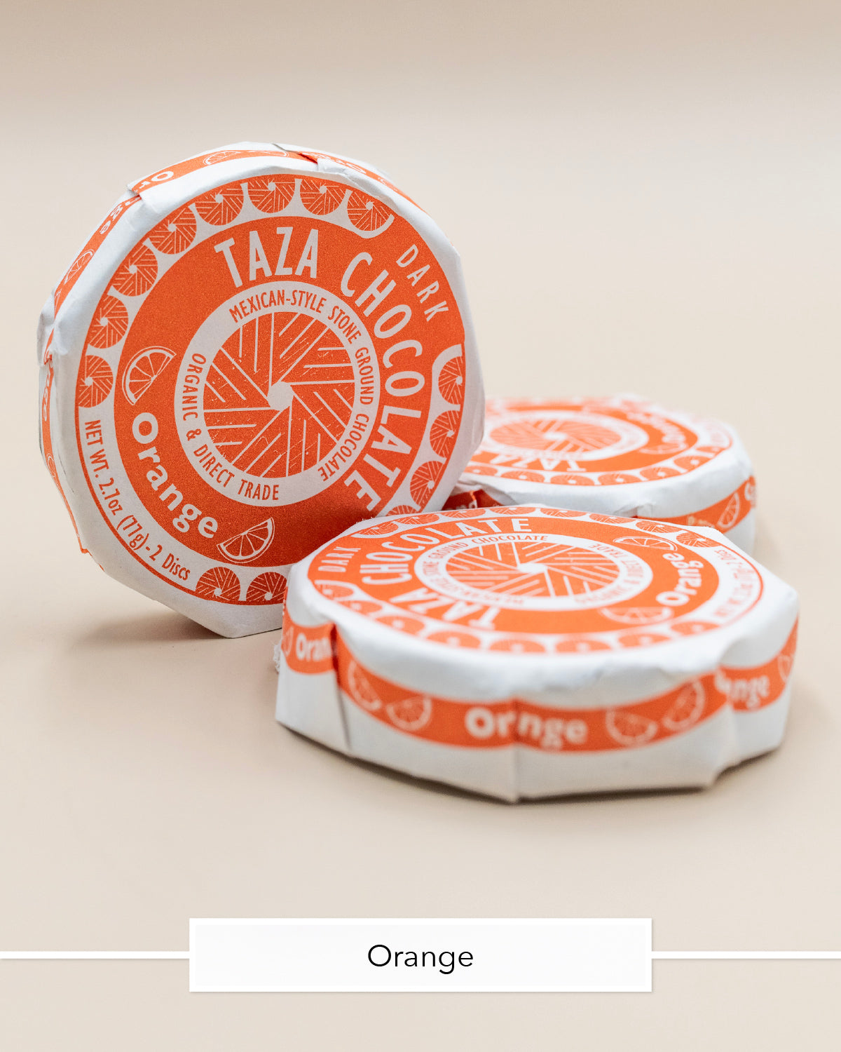 Taza Orange dark chocolate discs in bright orange and white paper wrappers